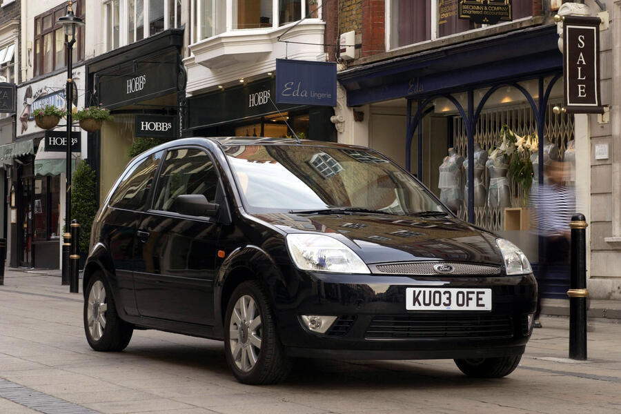 Black 2003 Ford Fiesta parked in front of shop on high street â€“ front quarter