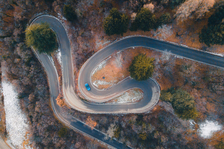 Ferrari Purosangue driving through Italian hills â€“ viewed from above