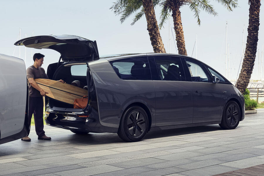 Person loading surfboard into the boot of a Li Auto Mega