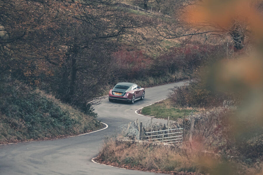 Rolls-Royce Spectre driving through countryside â€“ rear